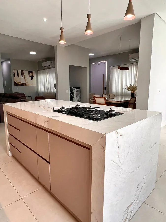 Ilha com cooktop e as salas ao fundo